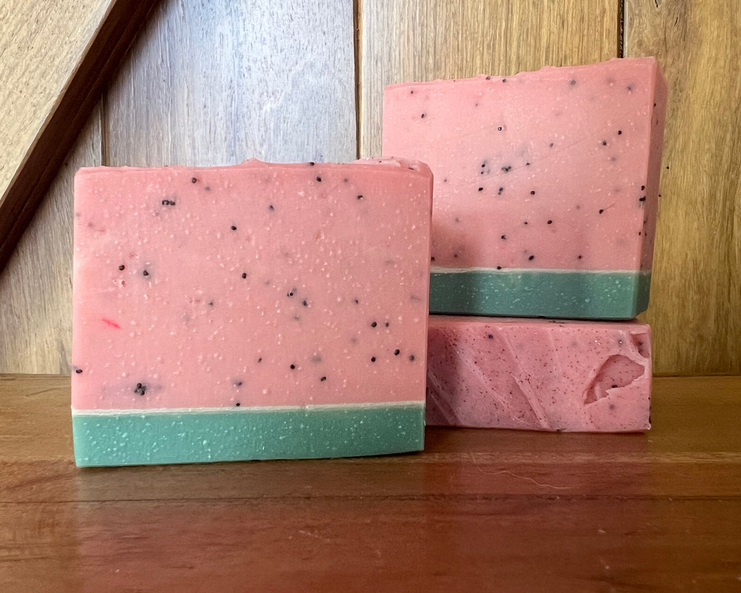 Two pink and green striped books stacked on a wooden surface