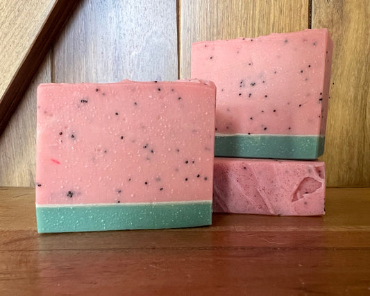 Two pink and green striped books stacked on a wooden surface