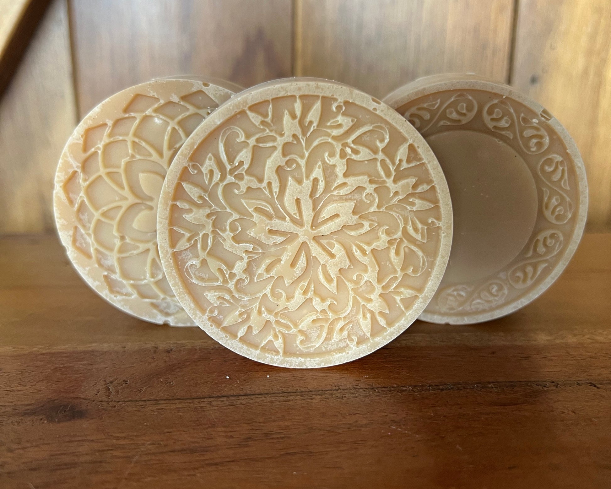 Three round, intricately patterned objects on a wooden surface