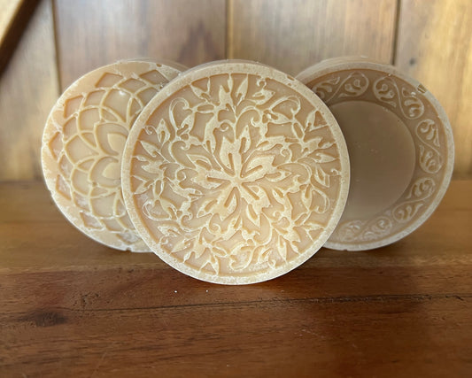 Three round, intricately patterned objects on a wooden surface