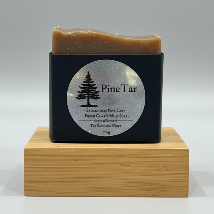 A set of handmade soap bar in black packaging with circular labels, displayed on a wooden stand.